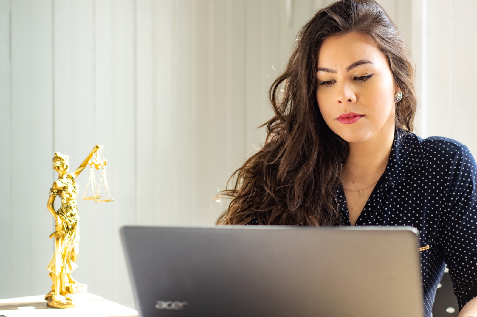 Legal professional at a desk with a justice scales figurine